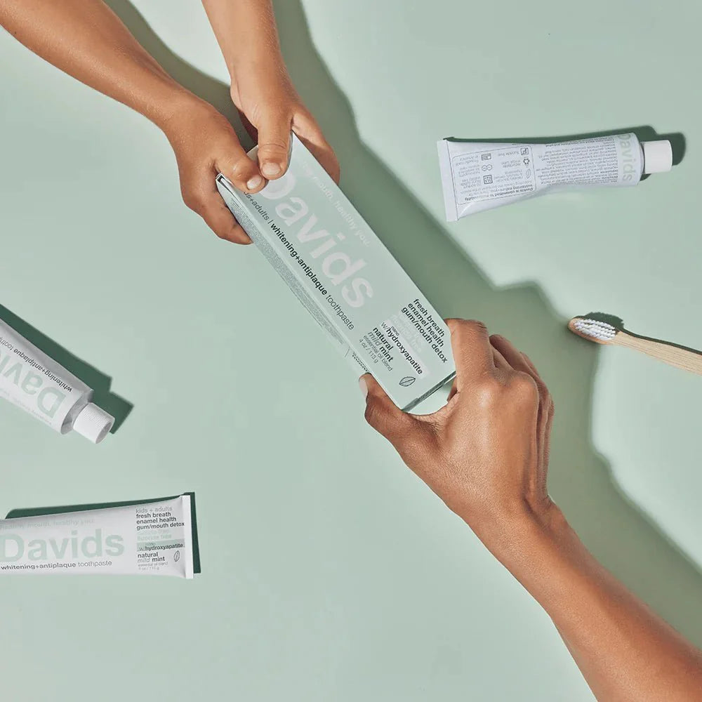 hands-passing-davids-toothpaste-box.jpg